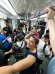 Tia smiling while riding a crowded subway train.
