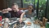 Tia grilling the food while Matt enjoys it at a Korean barbecue restaurant in Singapore.