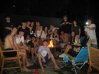 Mason with friends gather around a fire pit for a fun evening together outdoors.