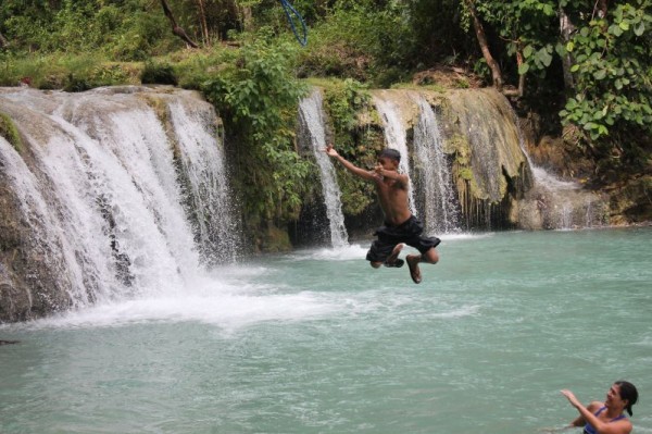 Junior doing the spider-man pose at Cambugahay Falls (Tia watching) (Siquijor)