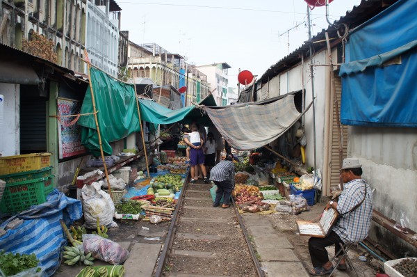 Train Umbrella Market...A train comes through here twice a day and the vendors move their items back while it passes