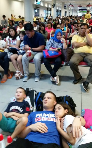 Manila Airport was a mess on Christmas Eve. Luckily we found a place to wait to board the plane on the floor in front of a TV